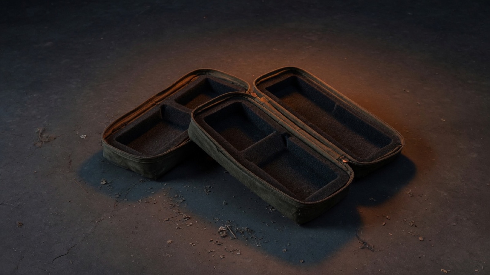 Empty padded radio cases sitting open on a dark workshop floor